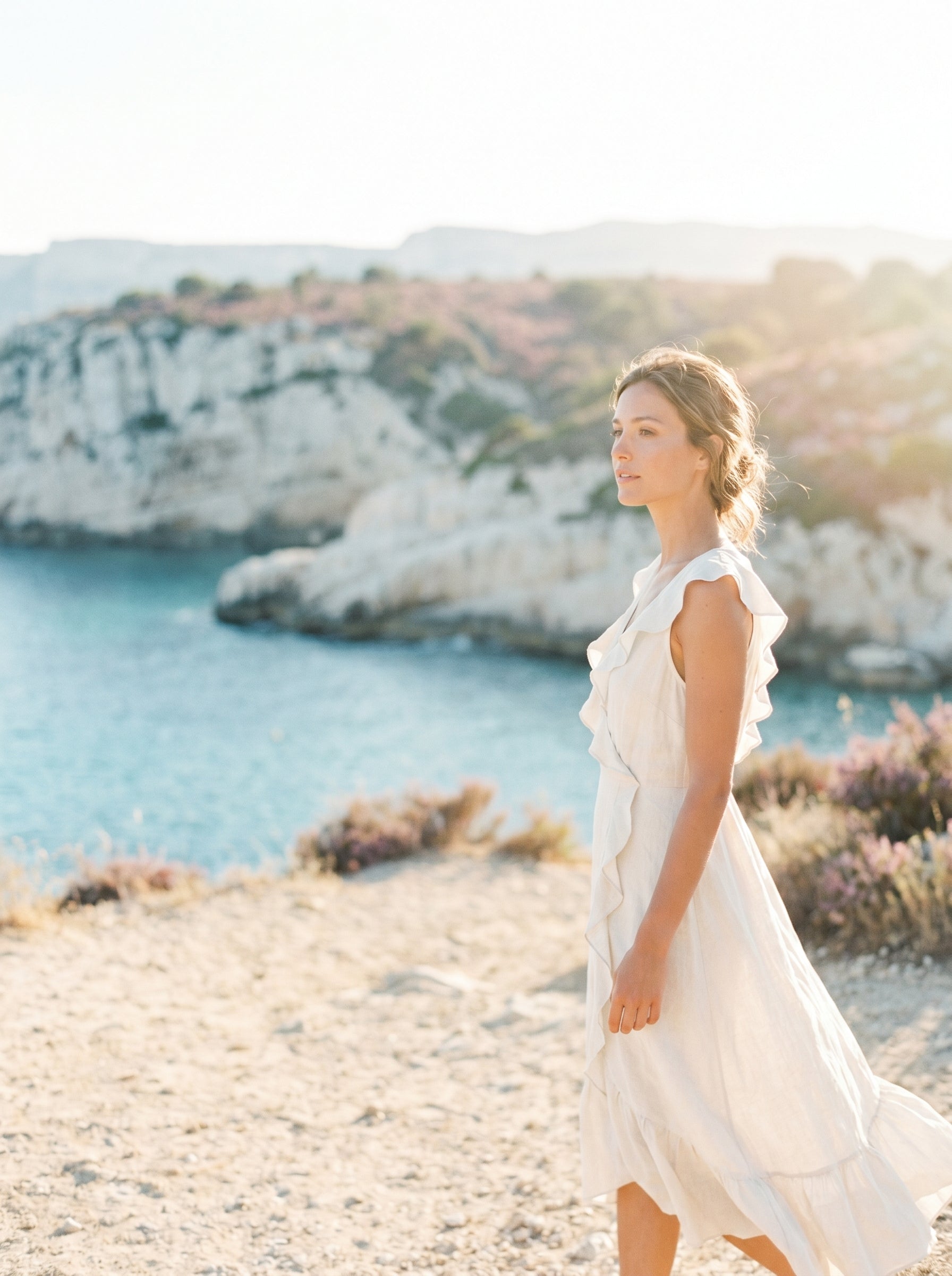 Femme en robe blanche sur les falaises de Cassis, lumière de fin de journée