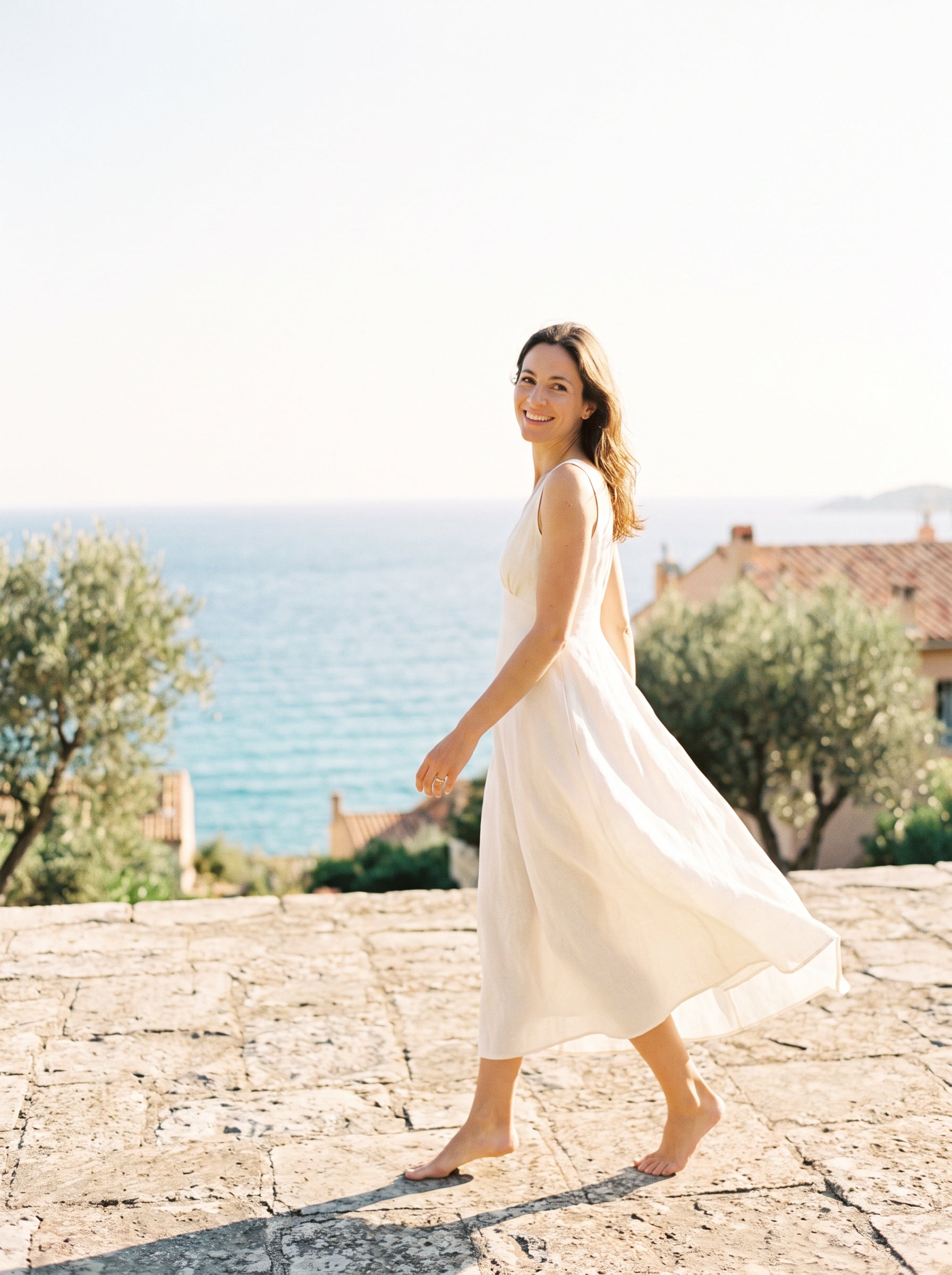 Femme marchant sur une terrasse face à la Méditerranée